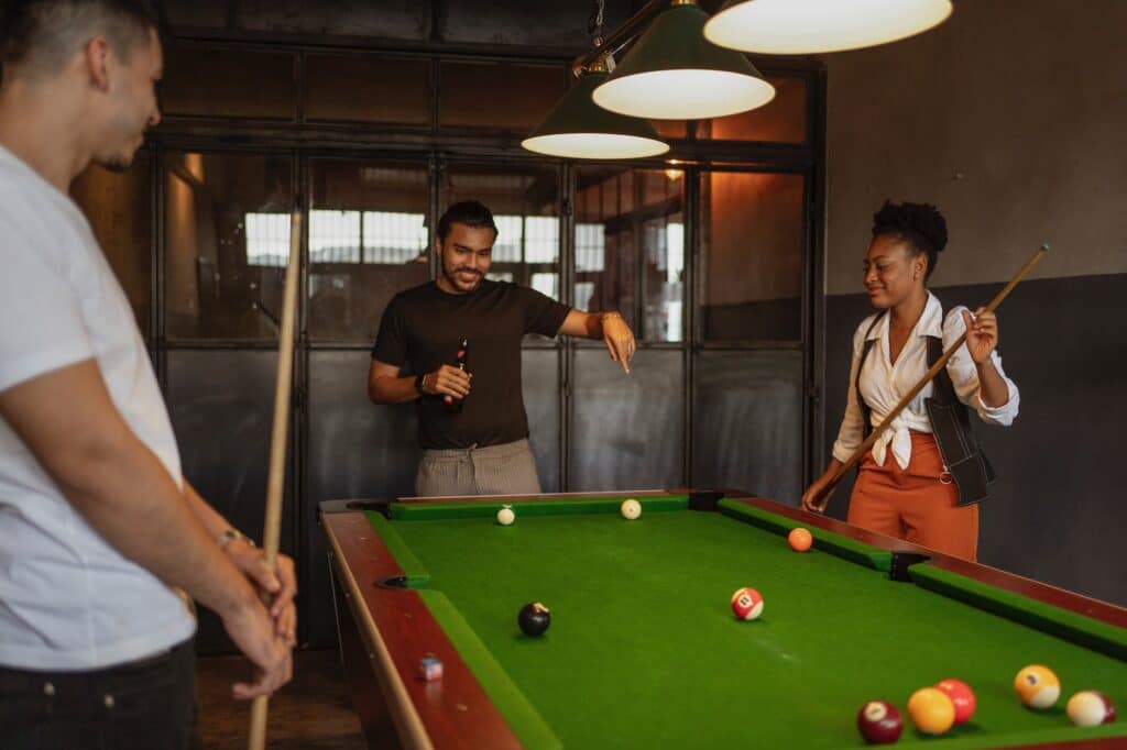people playing billiard and drinking beer